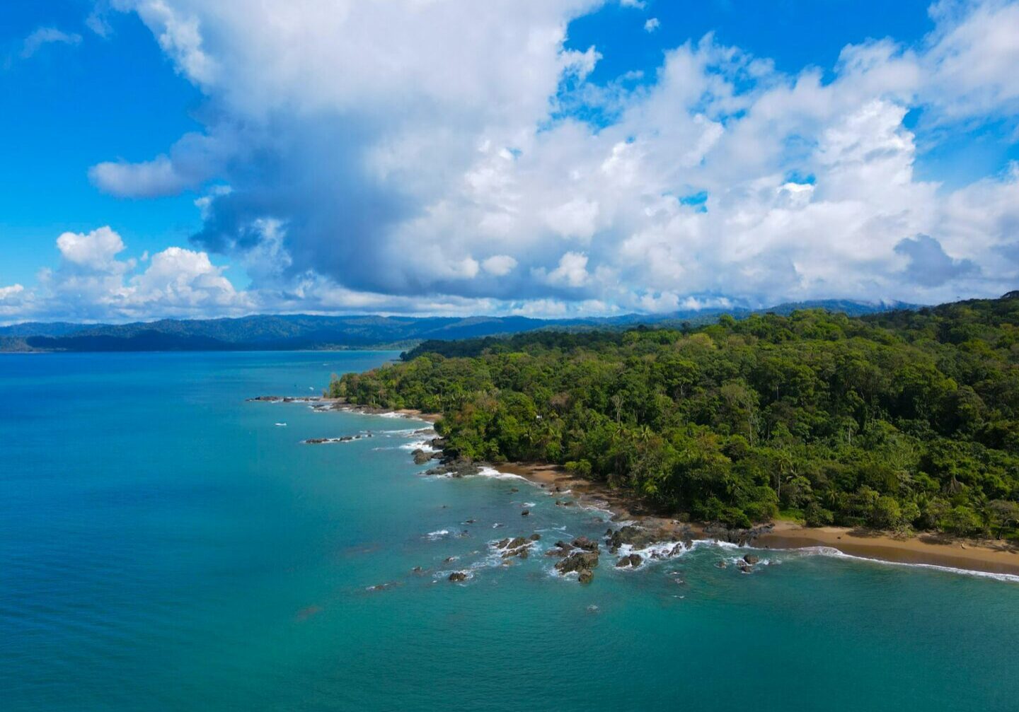 Costa Rica's green coastal landscape beside turquoise water