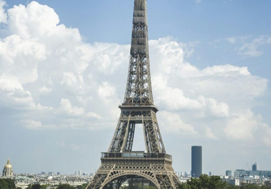 The Eiffel Tower above green trees in Paris